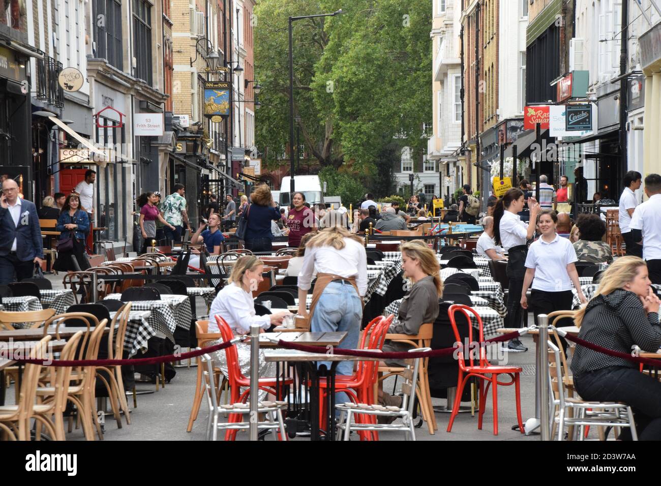 Crowd of people at bars and restaurants in Frith Street, Soho, London 2020. Sections of Soho have been blocked for traffic to allow temporary outdoor street seating and table service to facilitate social distancing during the pandemic. Stock Photo