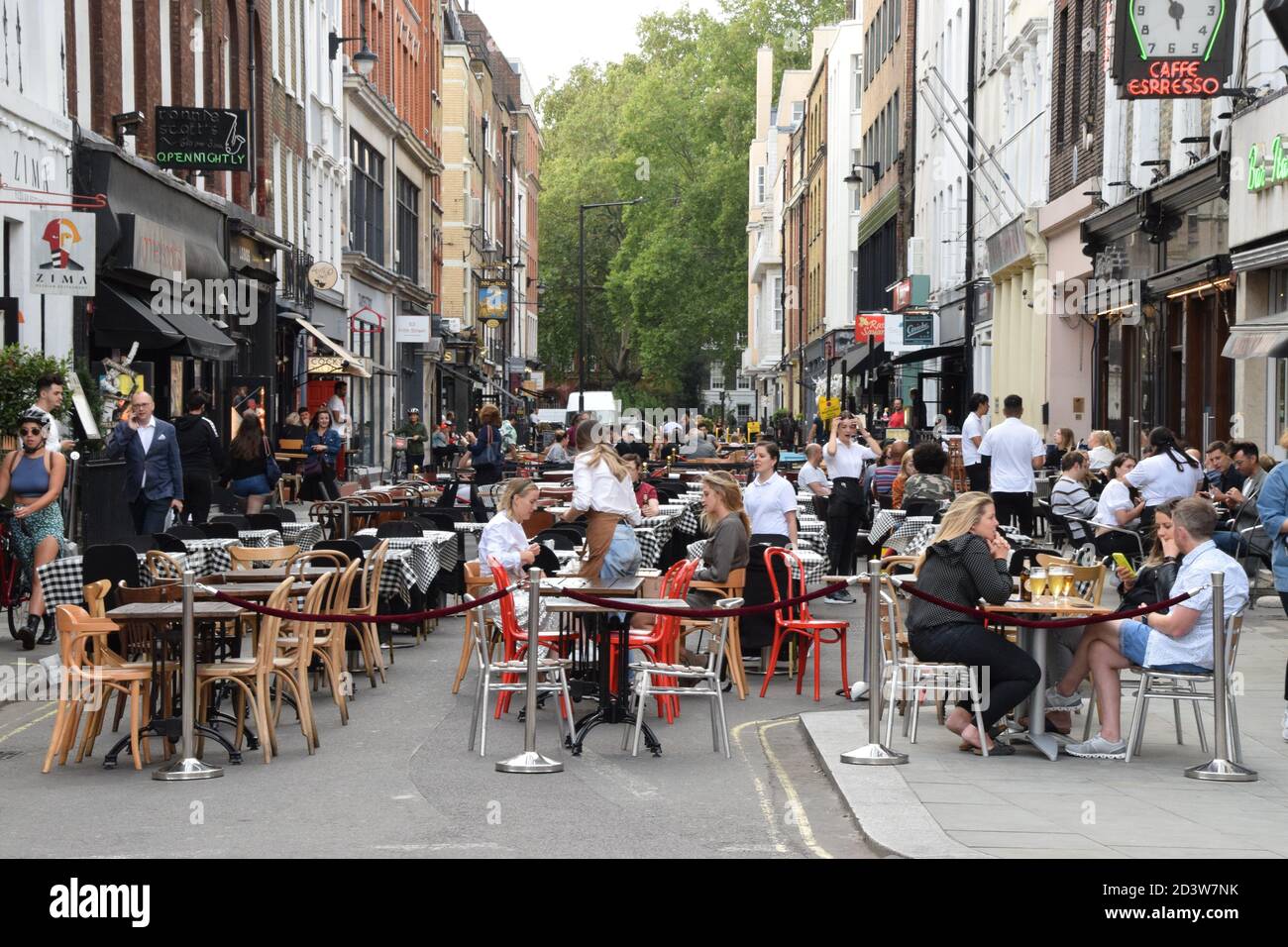 Crowd of people at bars and restaurants in Frith Street, Soho, London 2020. Sections of Soho have been blocked for traffic to allow temporary outdoor street seating and table service to facilitate social distancing during the pandemic. Stock Photo