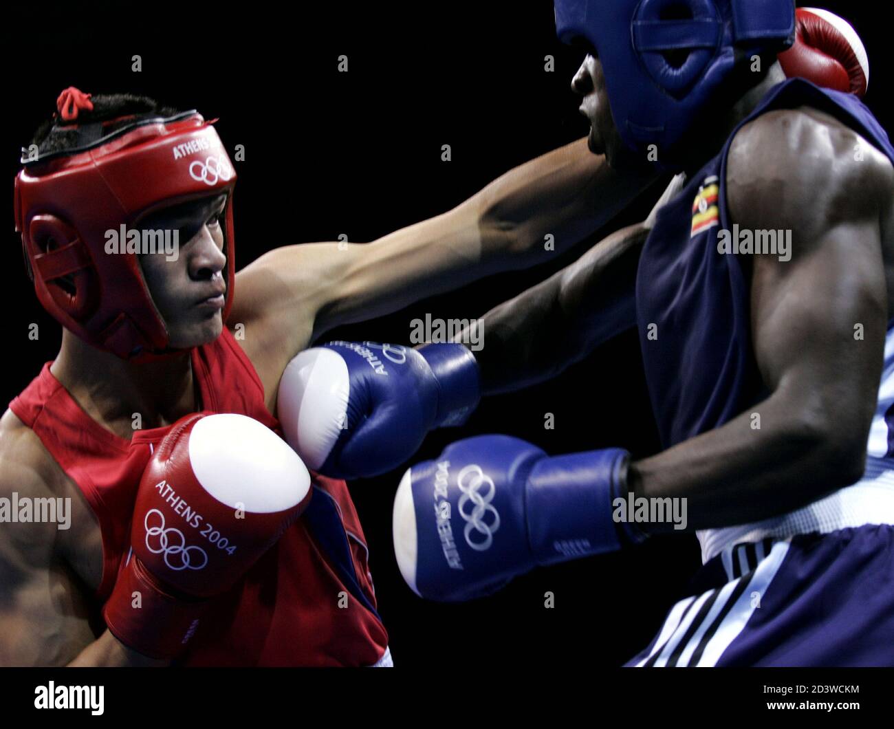 Suriya Prasathinphimai of Thailand (L) exchanges punches with Joseph Lubega (R) of Uganda during their middle weight (75kg) round of 32 boxing bout at the Athens 2004 Olympic Summer Games August 14, 2004. Prasathinphimai won the fight. Stock Photo