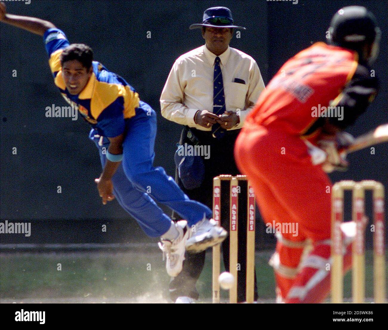 Sri Lankan fast bowler Chaminda Vaas (L) bowls to Zimbabwe batsman Andy Flower (R) as umpire Gamini Silva watches in the curtain raiser of the LG triangular tournament at Sinhalese Sports Club ground in the Sri Lankan capital Colombo on December 8, 2001. Vaas created a new world record by capturing eight wickets for 19 runs as the visitors were bowled out for 38 runs. Sri Lanka won the game by nine wickets. REUTERS/Anuruddha Lokuhapuarachchi  AL/CP Stock Photo
