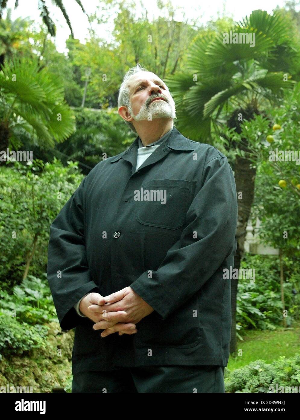 U.S. film director Brian De Palma stands in front of palm trees as he poses  for pictures at a hotel in central Rome November 19, 2002. [De Palma is in  the Italian