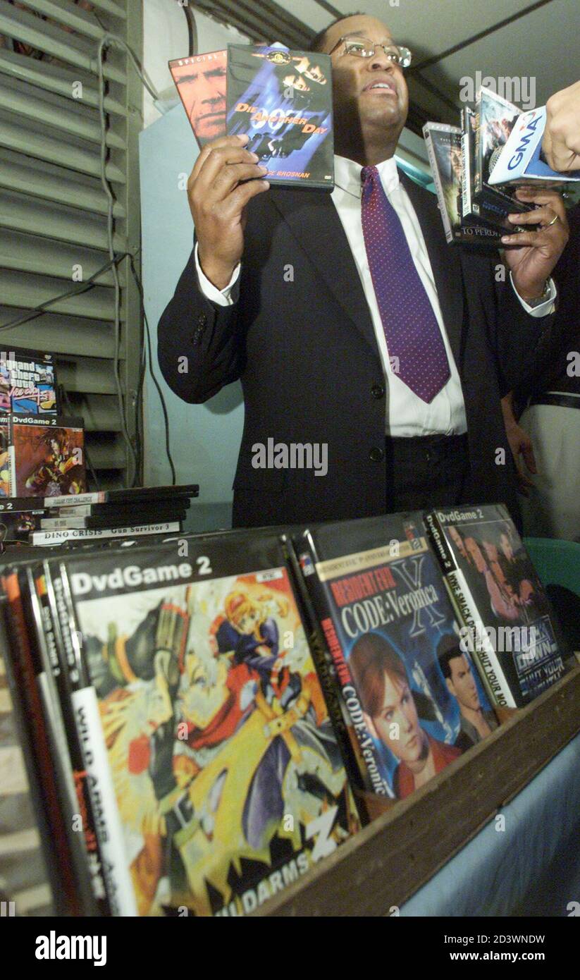 U.S. assistant secretary of commerce for market access and compliance  William Lash shows reporters pirated Digital Video Discs (DVDs) he bought  at a stall market in Manila January 11, 2003. Lash told