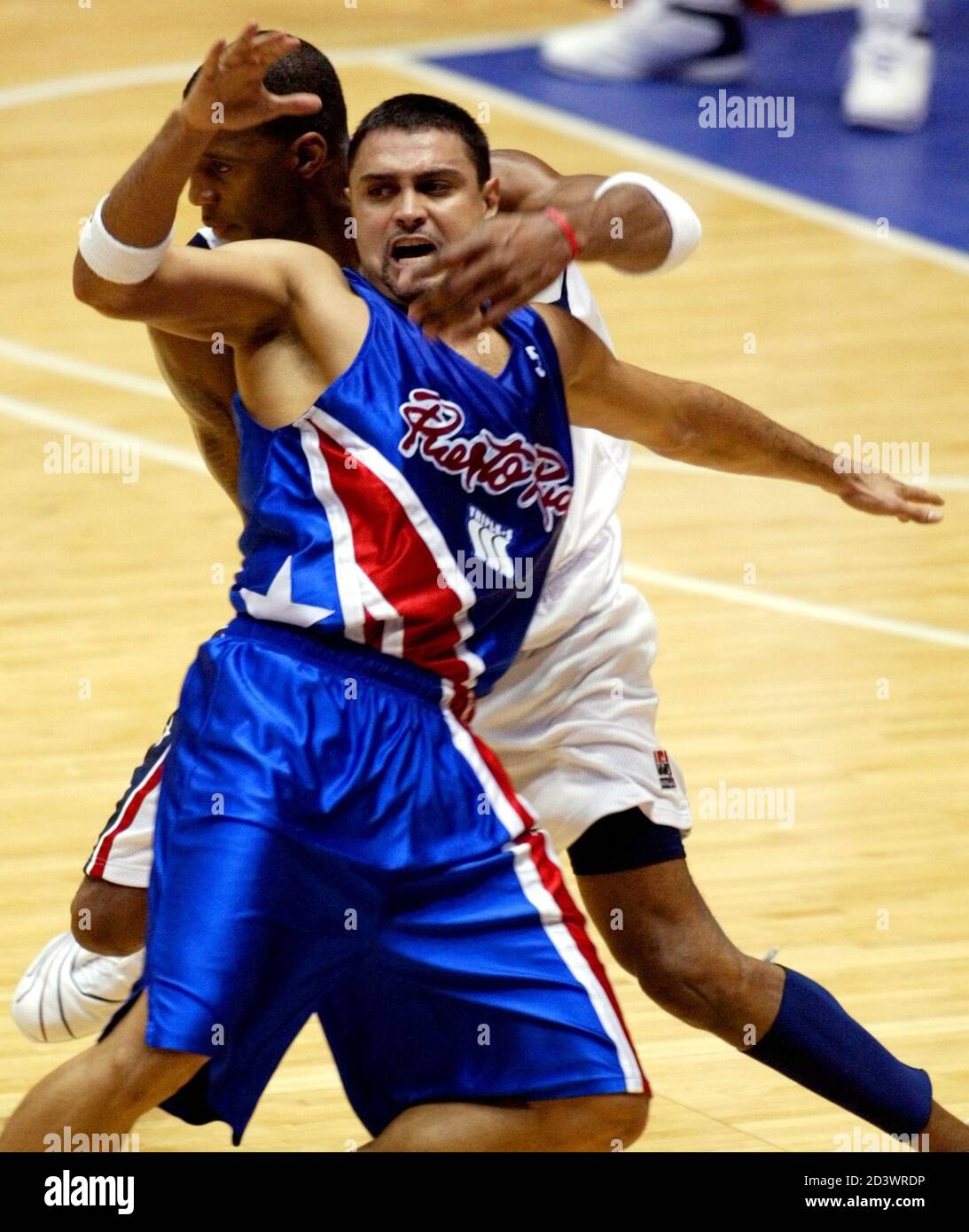 Puerto Rican guard Eddie Casiano (San Antonio Spurs) (R) is roughed up by USA guard Tracy McGrady (Orlando Magic) during first half action in the semifinal round of the 2003 FIBA Americas Men's Olympic Qualifying Tournament in San Juan, Puerto Rico, August 30, 2003. The top three teams in the tournament qualify for the 2004 Summer Olympics in Greece. REUTERS/Ana Martinez  JM Stock Photo