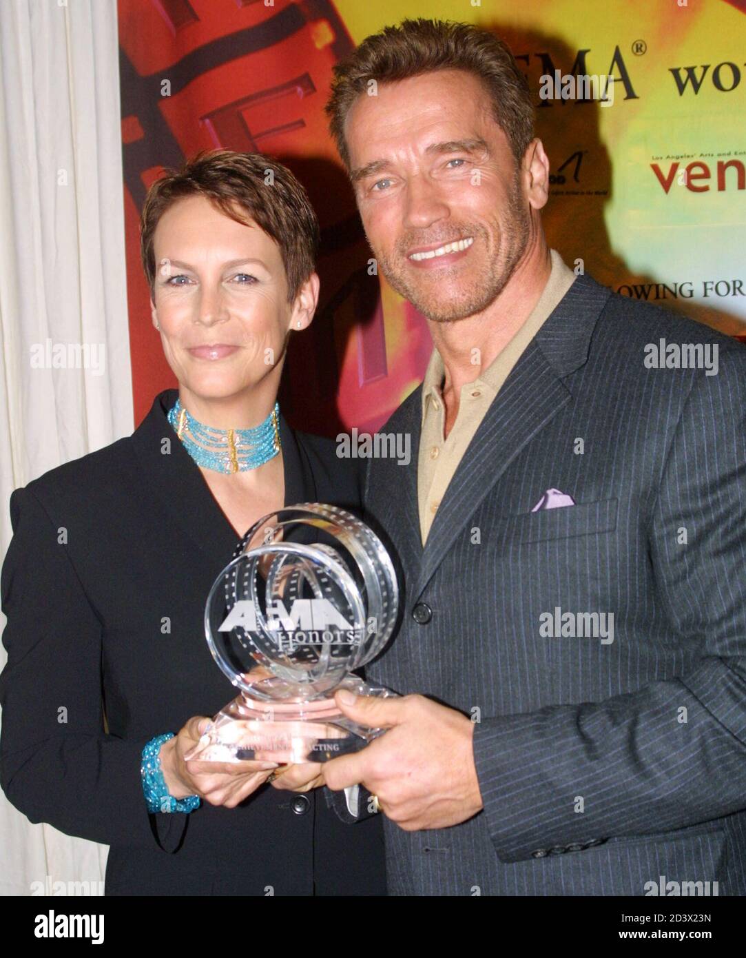 Actress Jamie Lee Curtis presents Arnold Schwarzenegger with an achievement  award during the American Film Marketing