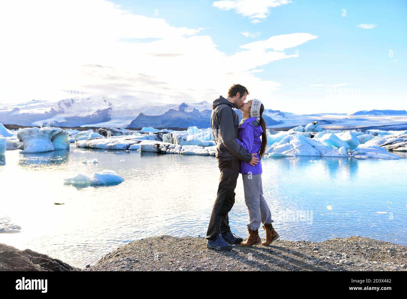 Couple kissing embracing in love on Iceland. People enjoying Jokulsarlon glacial lagoon. Romantic couple visiting destination landmark and tourist Stock Photo