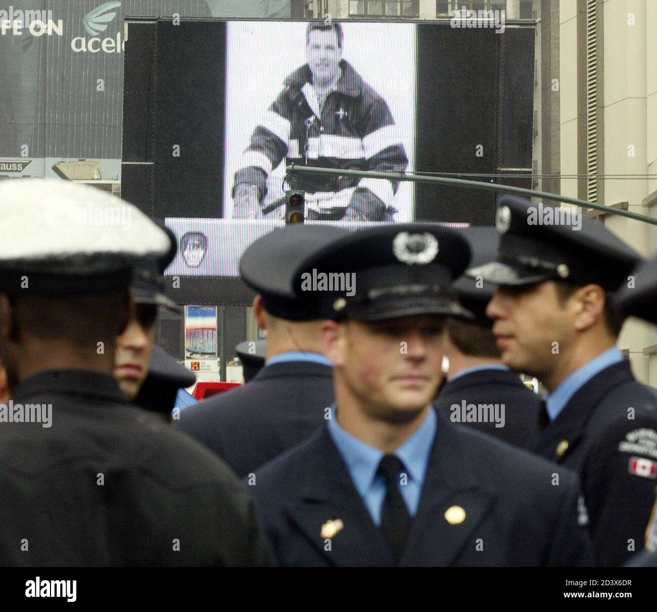 Thousands of firefighters from all over the world view the firefighters who died in the World Trade Center Attacks on a jumbotron outside Madison Square Garden in New York October 12, 2002. [Firefighters from across the world filled Madison Square Garden and the surrounding blocks on Saturday to honor the 343 firefighters who died in the World Trade Center hijack attack last year. Because last year's event was canceled due to the attack on the trade center, this year, an honor guard carried 356 flags, to also honor those firefighters who died in the line of duty in New York since mid-October 2 Stock Photo