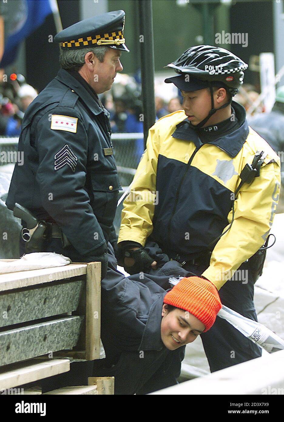 Two Chicago Police officers carry a handcuffed protester to a paddy wagon outside the Kluzcyinski Federal building in Chicago, March 21, 2003. Hundreds demonstrated against the war in Iraq. REUTERS/Frank Polich  FJP/GN Stock Photo