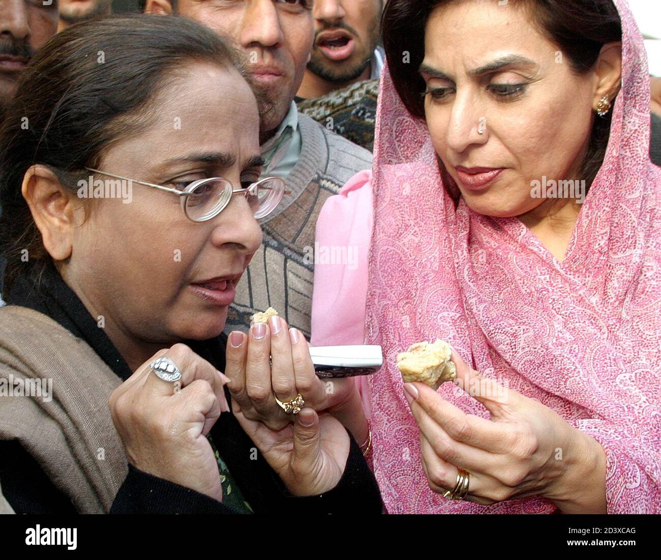 A supporter of the Pakistan People's Party gives sweets to Azra (L) sister of Asif Ali Zardari, husband of Pakistan's former Prime Minister Benazir Bhutto, after a Pakistani court decision to grant bail to Zardari in Islamabad November 22, 2004. A Pakistani court on Monday granted bail to Asif Ali Zardari, and officials from her party said the decision should result in his release after eight years in prison. REUTERS/Faisal Mahmood  MK/TW Stock Photo