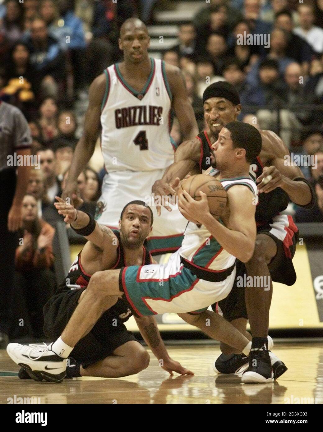 Portland Trail Blazers Scottie Pippen (R) tries to steel the ball away from  Vancouver Grizzlies Mahmound Abdul-Rauf after tripping over Trail Blazers  Damon Stoudamire (on the floor) as Grizzlies Stromile Swift (4)