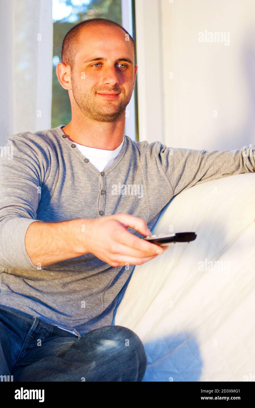 happy mand relaxing using remote controler tech Stock Photo