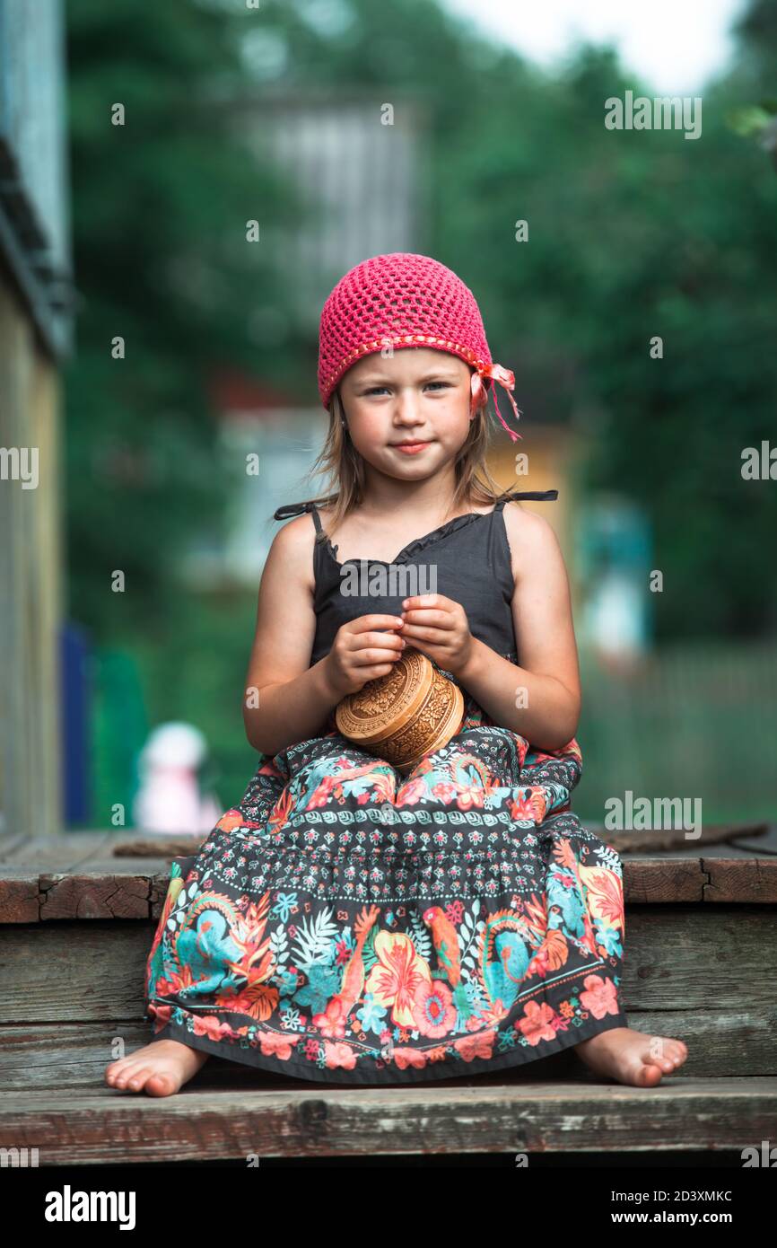 Little cute girl sitting on the porch of a village house Stock Photo ...