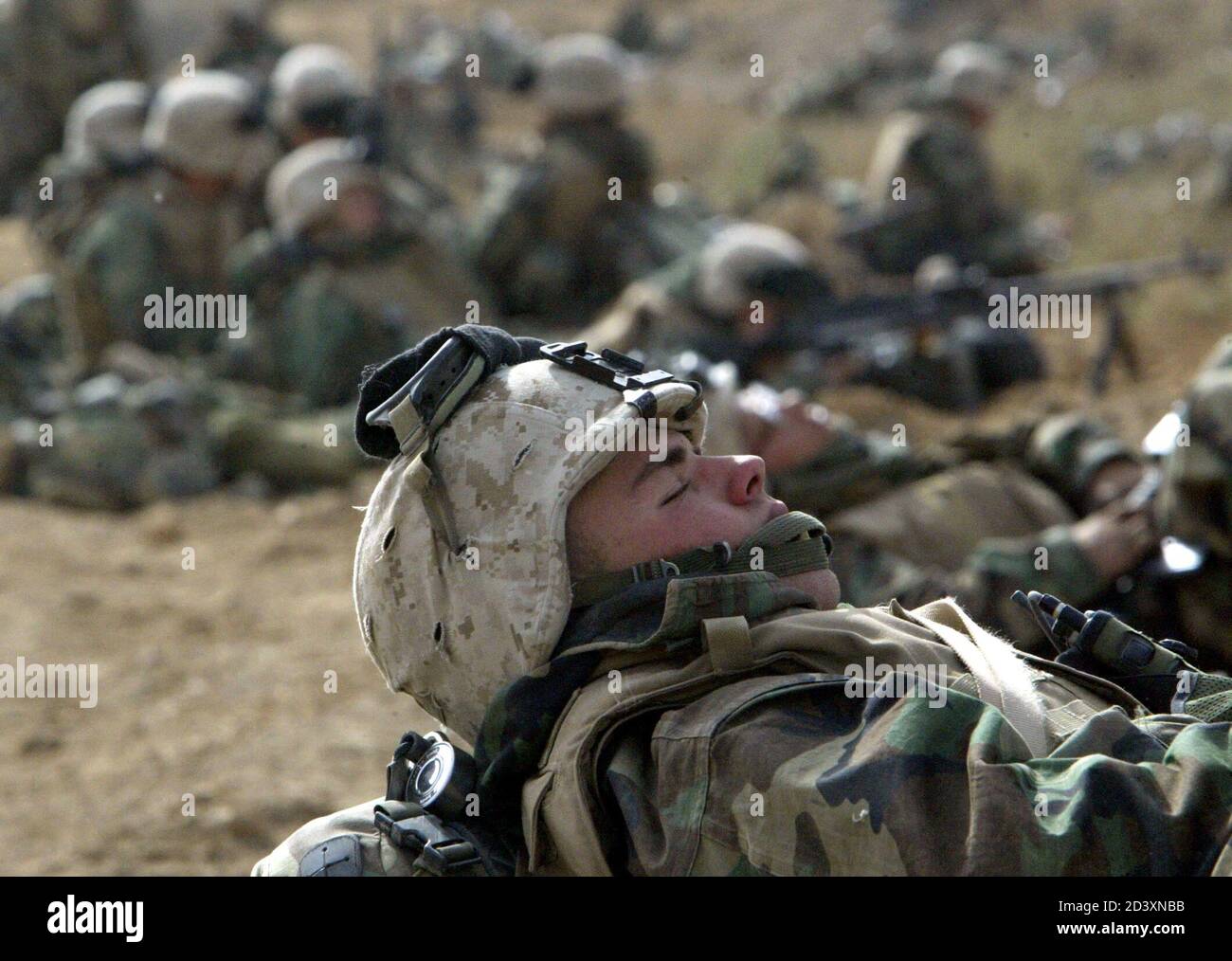 A U.S. Marine from Lima Company, a part of the 7th Marine Regiment, takes a short break before a final push on the road South-East from the Iraqi capital Baghdad on April 5, 2003. [Iraq said it had beaten off a U.S. attack on its positions near Baghdad overnight as the thunder of repeated explosions reverberated through the city into Saturday. U.S. military sources said at least 20 Abrams battle tanks and 10 Bradley fighting vehicles had pushed into southern Baghdad on Saturday in the closest land advance to the heart of the city.] Stock Photo