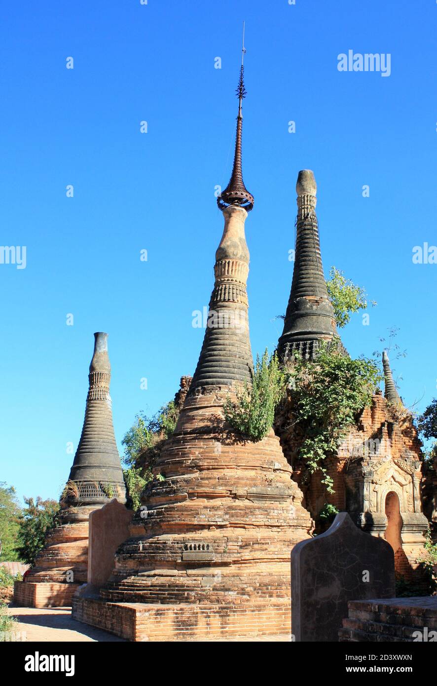 Ruins of old stone pagodas with green plants growing on them at In Dien located on the southwestern side of Inle Lake, Myanmar Stock Photo