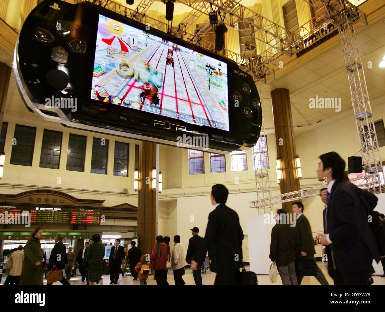 An eight metre wide (26 feet) PlayStation Portable (PSP) mock-up hangs  above passers-by at a Tokyo station November 29, 2004. Sony plans to begin  selling its new PSP hand-held console, which will
