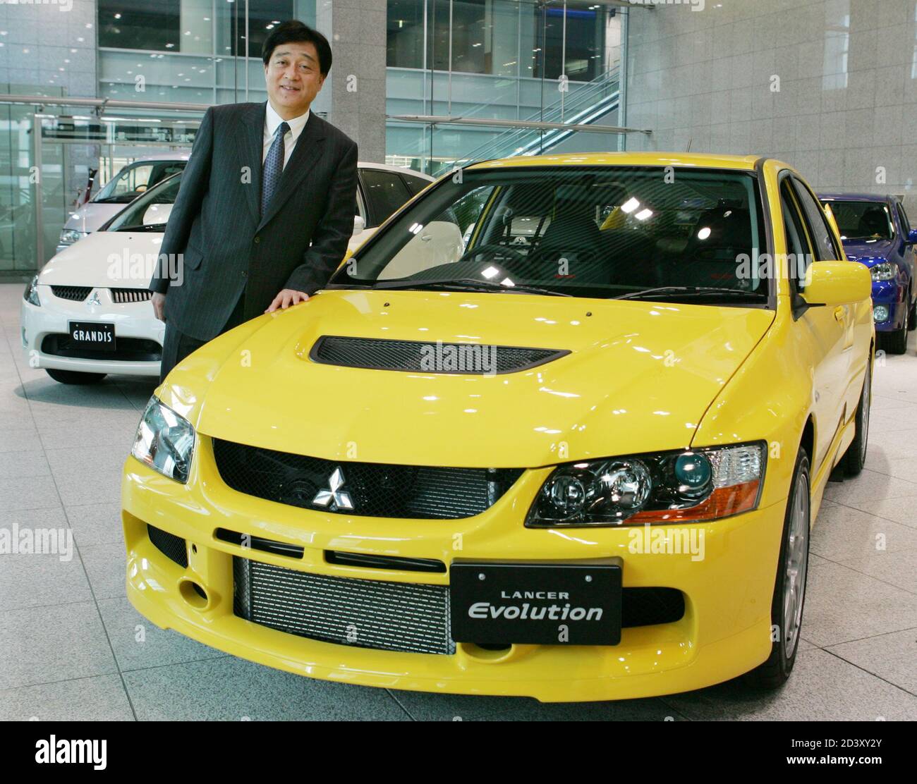 Mitsubishi Motors Corporation President Osamu Masuko Poses Next To The Company S New Sports Sedan The Lancer Evolution Ix At The Corporation S Headquarters In Tokyo March 2 05 The Car With A 2 0 Litre