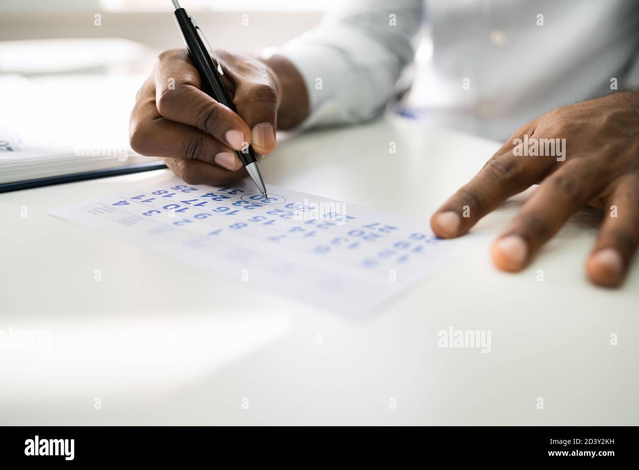 African American Looking In Calendar At Office Desk Stock Photo Alamy