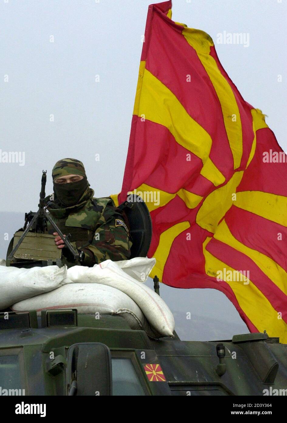 A special police forces member sits on an APC as they pass a Macedonian