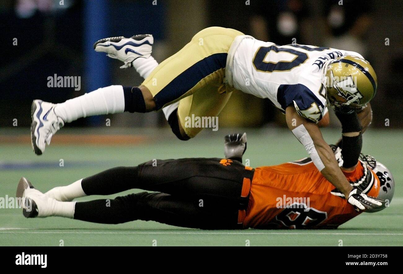 Winnipeg Blue Bombers cornerback Harold Nash (top) dives onto B.C. Lions  wide receiver Rob Turner during first half CFL play in Vancouver June 20,  2003. Roberts was called for pass interference on