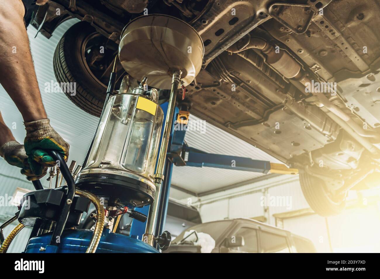 Changing Gear Oil or Engine or Motor OIL in Car Service with auto on lift, maintenance concept. Stock Photo