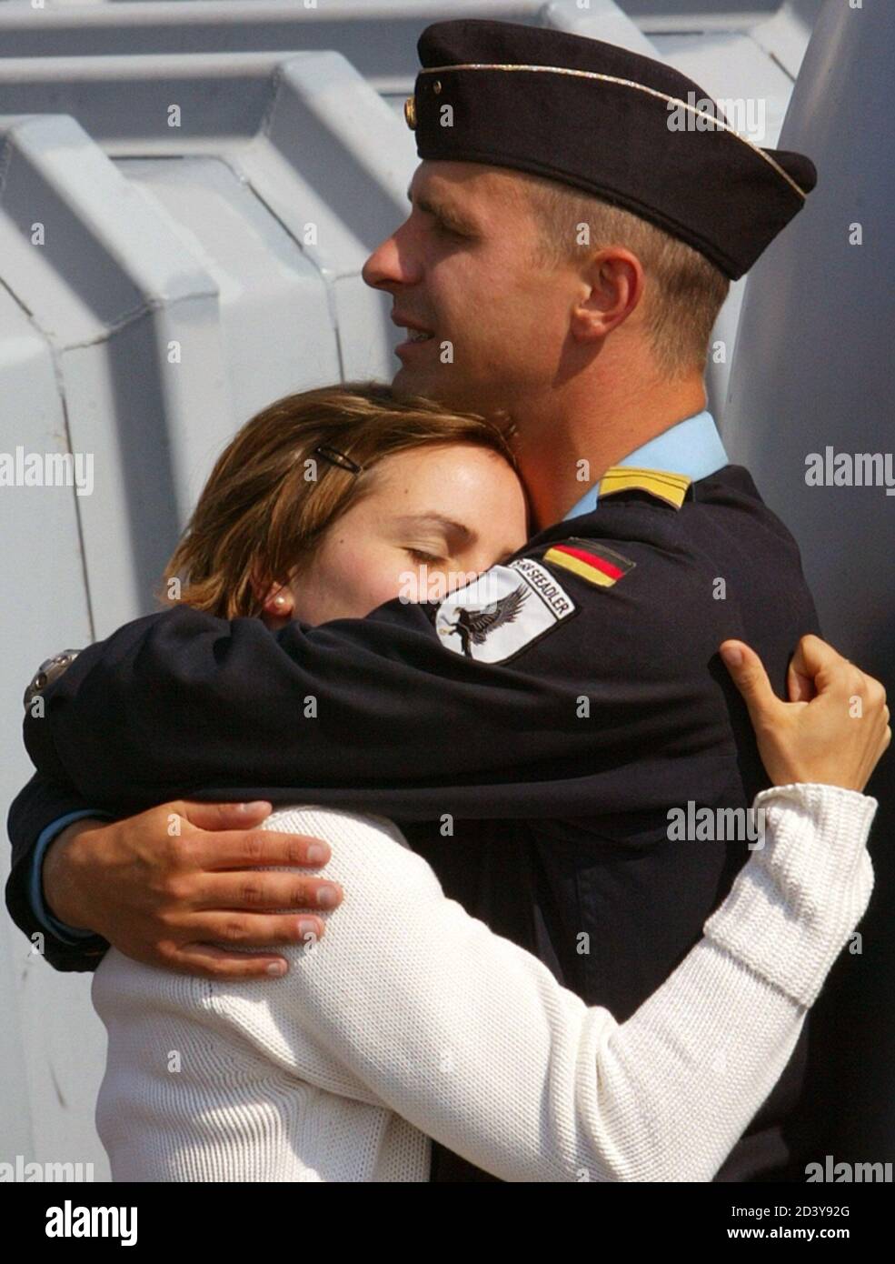 GERMAN NAVY CAPTAIN-LIEUTENANT HEINICKE EMBRACES HIS GIRLFRIEND KUHRT AFTER GERMAN NAVY BOATS ARRIVED AT THE NAVAL PORT OF WARNEMUENDE.  German Navy captain-lieutenant Oliver Heinicke embraces his girlfriend Kristina Kuhrt after a German Navy boats arrived at the Baltic sea naval port of Warnemuende near Rostock April 30, 2004. German fast patrol boats Seeadler and Dachs and tender Elbe returned from a 3-month employment to carry out anti-terrorism surveillance operations in the Strait of Gibraltar. The patrols are part of NATO's 'Active Endeavour' operation to monitor activities in the Medite Stock Photo