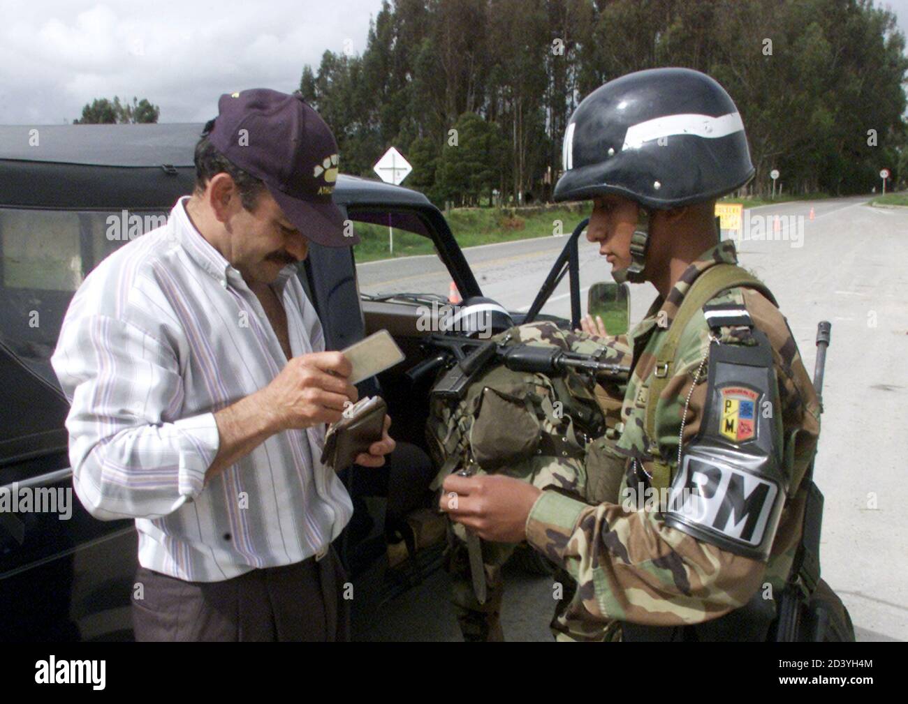 A Colomibian citizen shows his documents to a soldier in a check point in the village of Guasca, near Bogota, May 22, 2002. The Colombian presidential election will be held on May 26. REUTERS/Eliana Aponte  EA/MMR Stock Photo