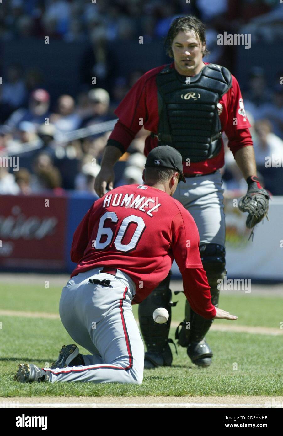 Cincinnati Reds third baseman Tim Hummel (below) can't make the catch as catcher Corky Miller stands behind their game with the Cleveland Indians in Winter Haven, Florida March 22, 2004. Hummel