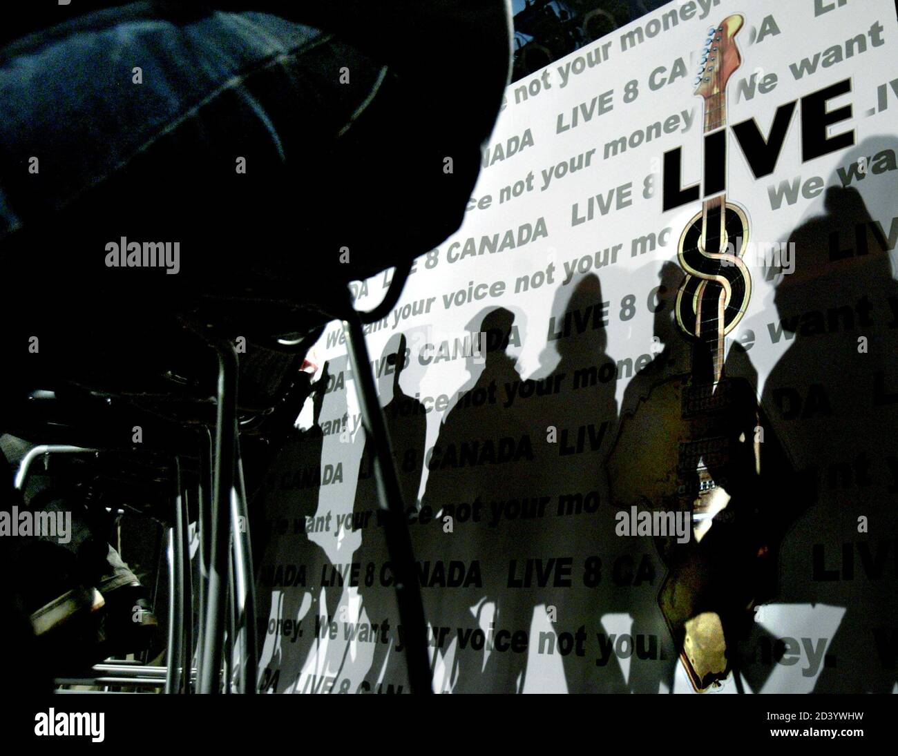 Musicians Shadows Are Cast During A News Conference Announcing Details Of The Canadian Live 8 Concert In Toronto Musicians Shadows Are Cast On A Background Stage Sign During A News Conference Announcing