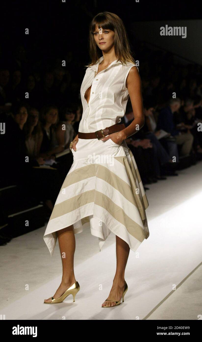 A model for the design house of Anne Klein wears a white and grey-striped bottom and a silk, sleeveless dress with a brown leather belt, from the Anne Klein Spring 2003 collection in New York on  September 19, 2002. Stock Photo