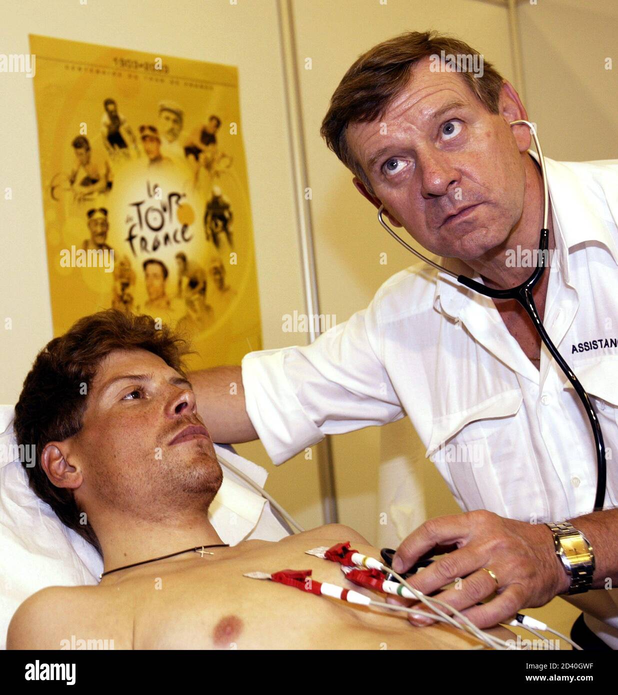 Tour de France's doctor Gerard Porte (R) checks the heartbeat of German  cyclist Jan Ullrich of the Bianchi team during the traditional medical  check-up July 4, 2003. The 100th anniversary Tour de