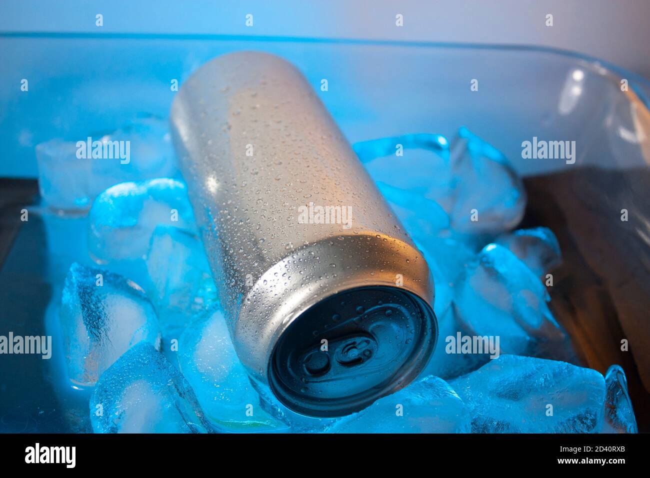Water drops on surface of silver can lying on blue ice cubes without people in Mexico Stock Photo