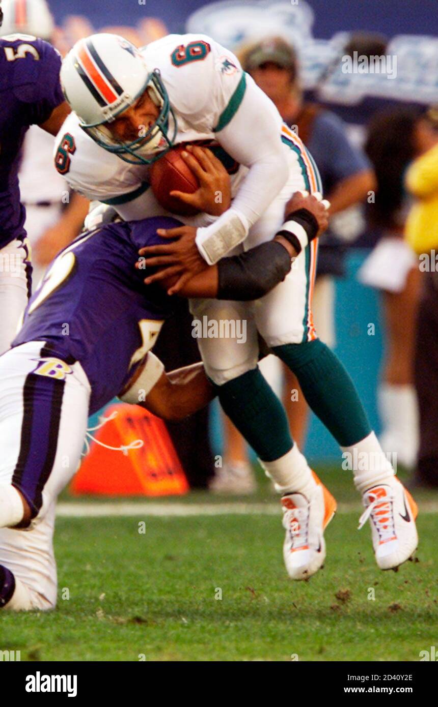 Miami Dolphins' quarterback Ray Lucas (R) is stopped by Baltimore Ravens'  defender Corey Harris during NFL wild card playoff action at Pro Player  Stadium in Miami, Florida, January 13, 2002. REUTERS/Colin Braley