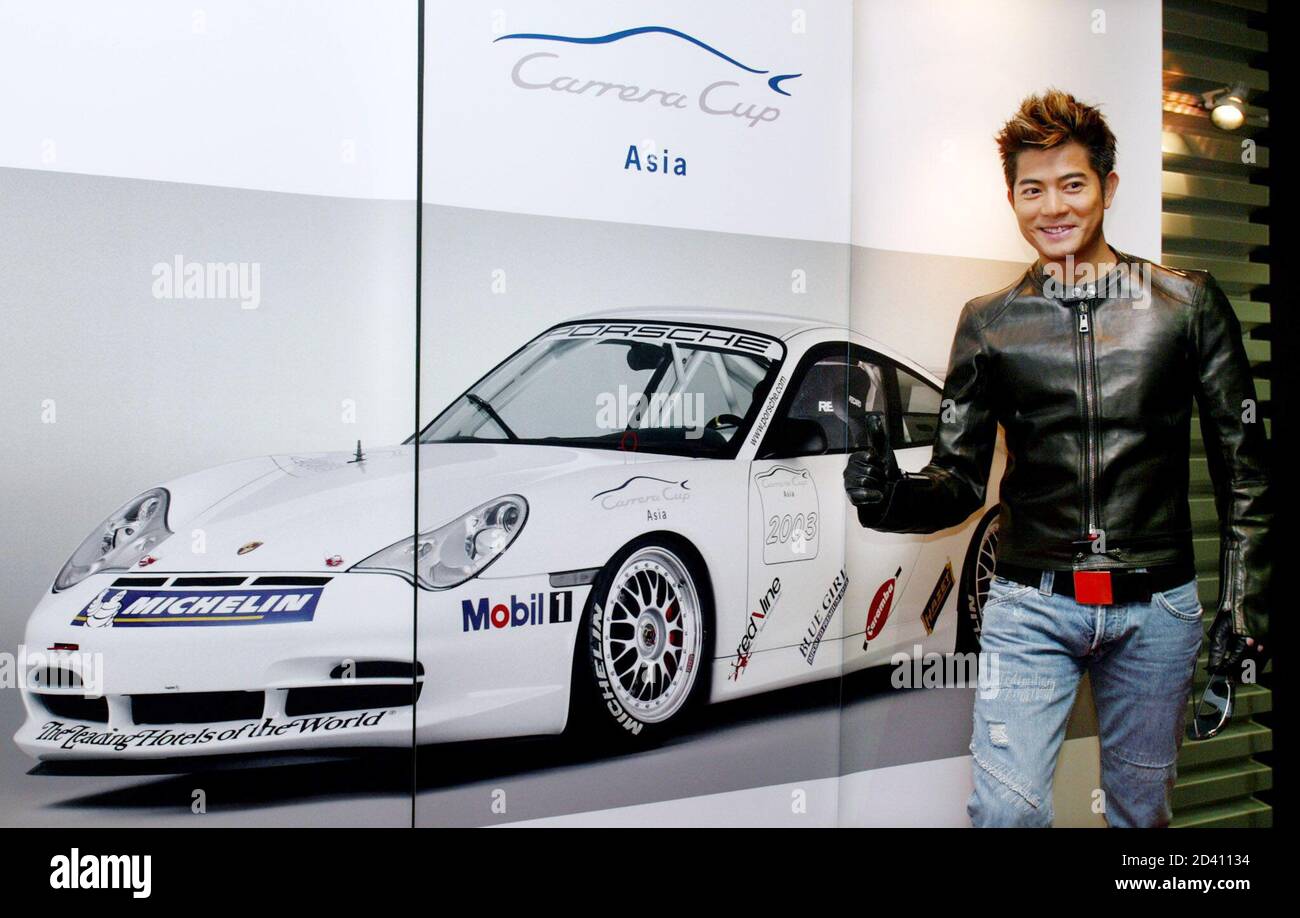 Hong Kong singer-actor Aaron Kwok poses in front of a poster for the  Porsche 911 GT3 at a news conference in Hong Kong January 28, 2003. Kwok  will drive a racing car
