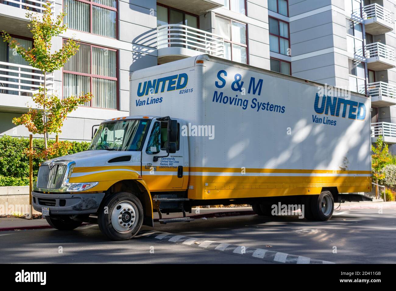S&M Moving company truck waits for customers in an outdoor parking lot near an apartment. S&M Moving is a certified agent of United Van Lines - San Jo Stock Photo