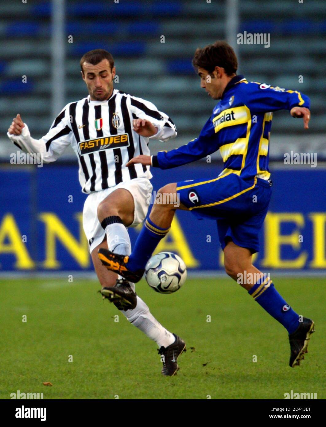Juventus's Paolo Montero (L) challenges Parma's Marco Marchionni during their Serie A soccer match at the Delle Alpi Stadium in Turin December 14, 2003. Juventus won the match 4-0. REUTERS/ Giampiero Sposito  GS/JV Stock Photo