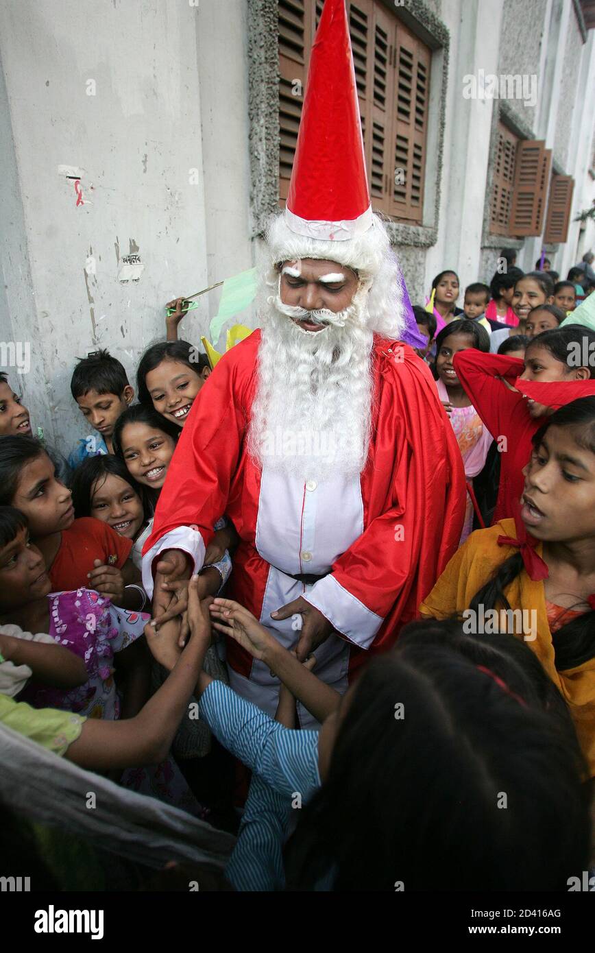 Indian street children crowd around a man dressed as Santa Claus in front of the Missionaries of Charity, the global order founded by Mother Teresa in 1950, in Calcutta December 21, 2004. About 200 street children participated in the rally, which was organised by a Christian group pressing for better living conditions for these disadvantaged youngsters. REUTERS/Jayanta Shaw  JS/LA Stock Photo
