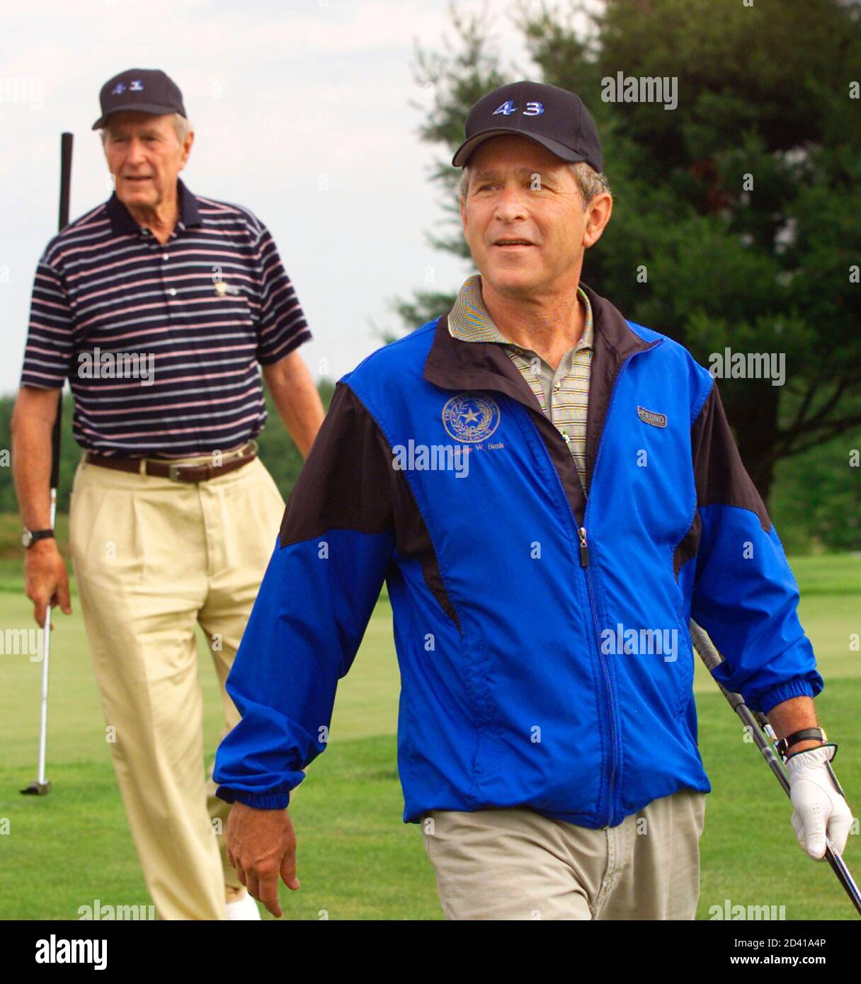 The 43rd U.S. President George W. Bush (R) and his father, the 41st President, George Bush walk from the 18th green after playing a round at the Cape Arundel Golf Club in Maine July 6, 2001. President George W. Bush is celebrating his 55th birthday today. The father-son golf tandem are sporting hats bearing the numbers 41 and 43 reflecting their presidencies. Stock Photo