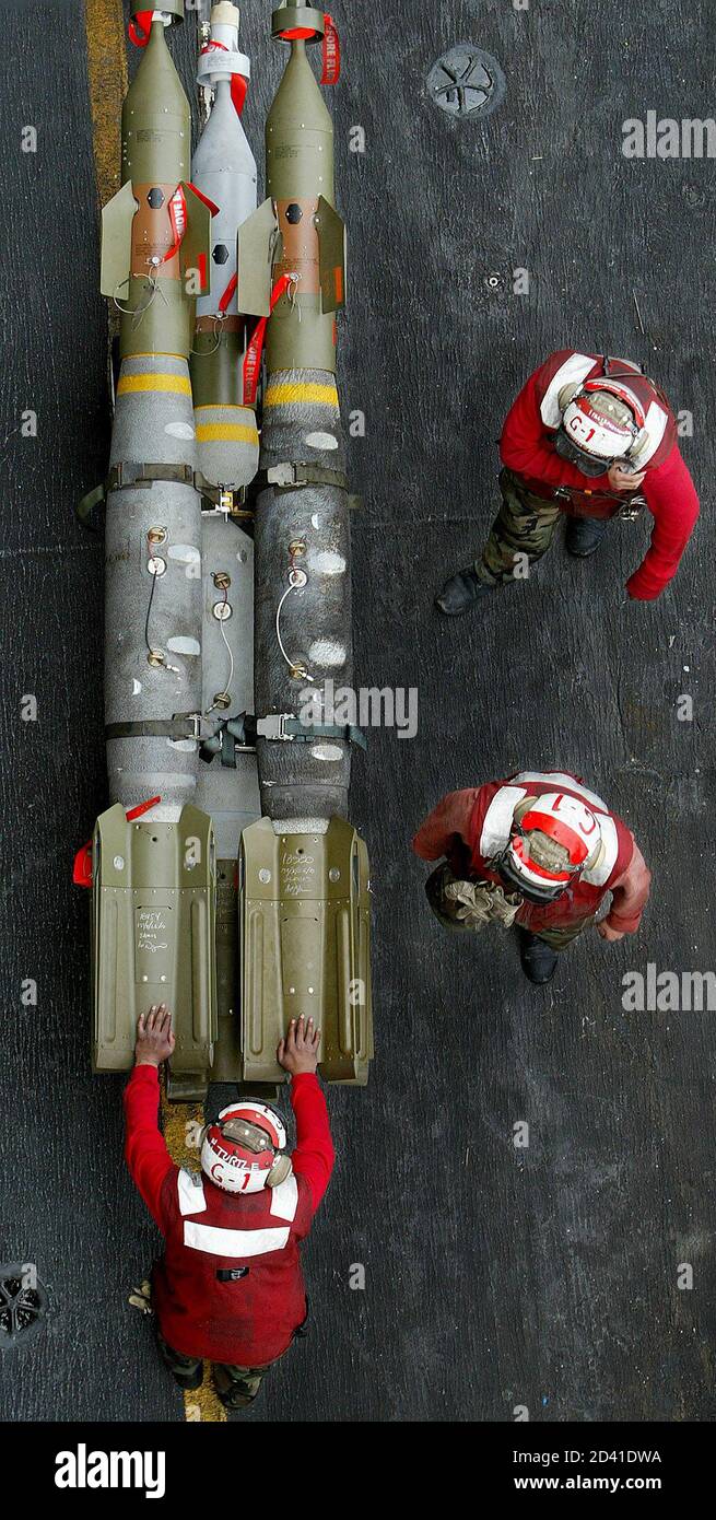 AN AVIATION ORDANANCEMAN PUSHES LASER GUIDED BOMBS ABOARD THE AIRCRAFT CARRIER USS KITTY HAWK IN THE GULF. Stock Photo