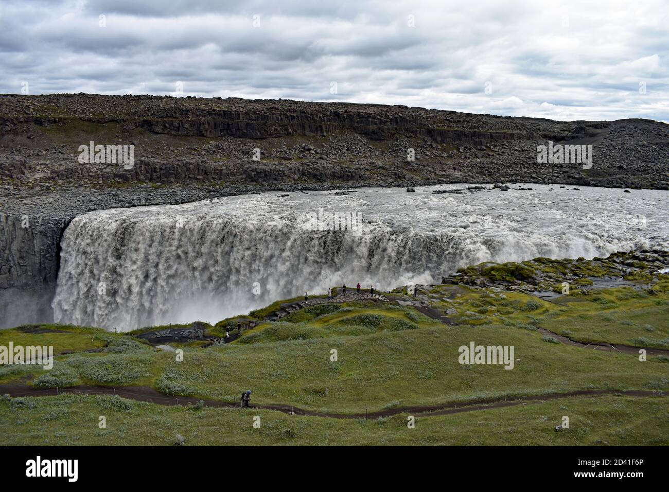 Dettifoss Waterfall in Northeast Iceland. Visitors and tourists can be seen wondering along the path that follows the rim of Jokulsargljufur Canyon. Stock Photo