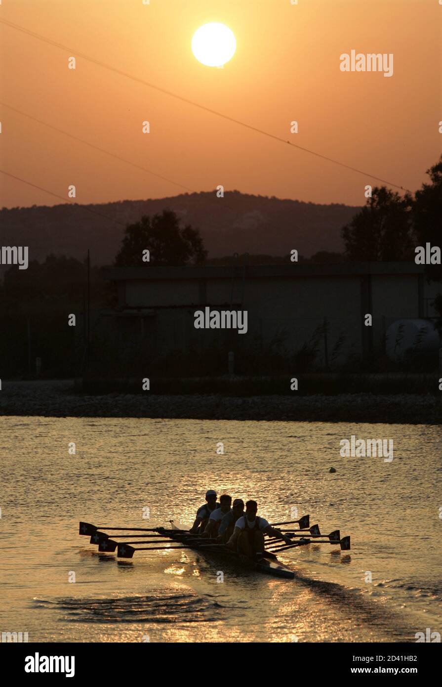 Members of the Swiss men's quadruple scull train as the sun rises over the Schinias Olympic Rowing Centre prior to competition at the Athens 2004 Olympics, August 15, 2004. REUTERS/Andy Clark  AC/DL Stock Photo