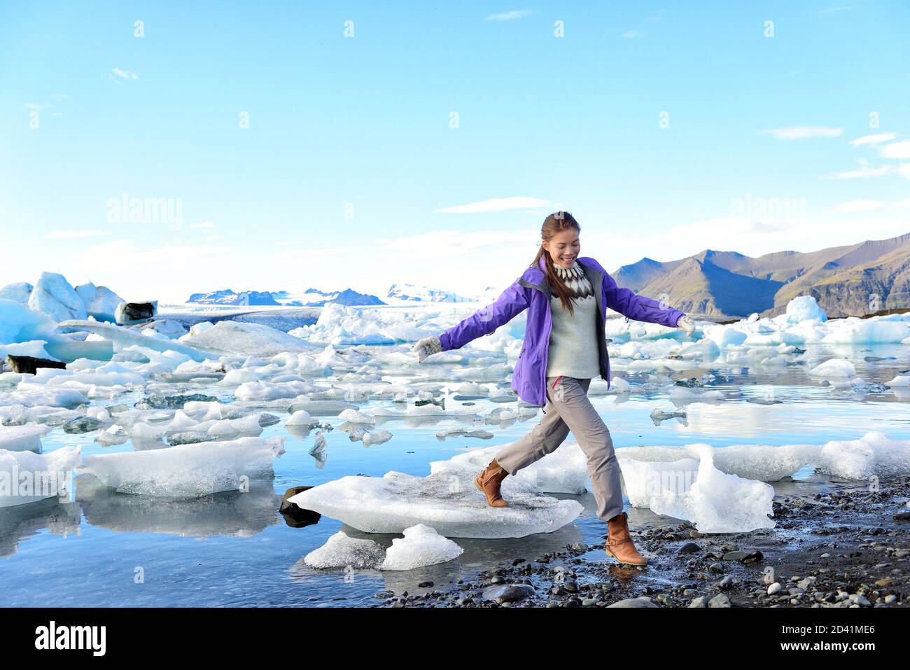 Iceland travel tourist walking on ice looking at view of nature landscape Jokulsarlon glacial lagoon on Iceland. Woman hiking by tourist destination Stock Photo