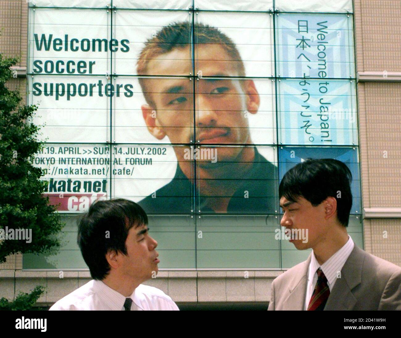 Tokyo Businessmen Chat In The Capital S Marunouchi District Near A Huge Banner Of Japan S Star Midfielder Hidetoshi Nakata On May 31 02 The World Cup Finals Kick Off On Friday In Seoul Tokyo Businessmen Chat In The Capital S Marunouchi District Near A Huge Banner Of Japan S Star Midfielder Hidetoshi Nakata On May 31 02 The World Cup Finals Kick Off On Friday In Seoul