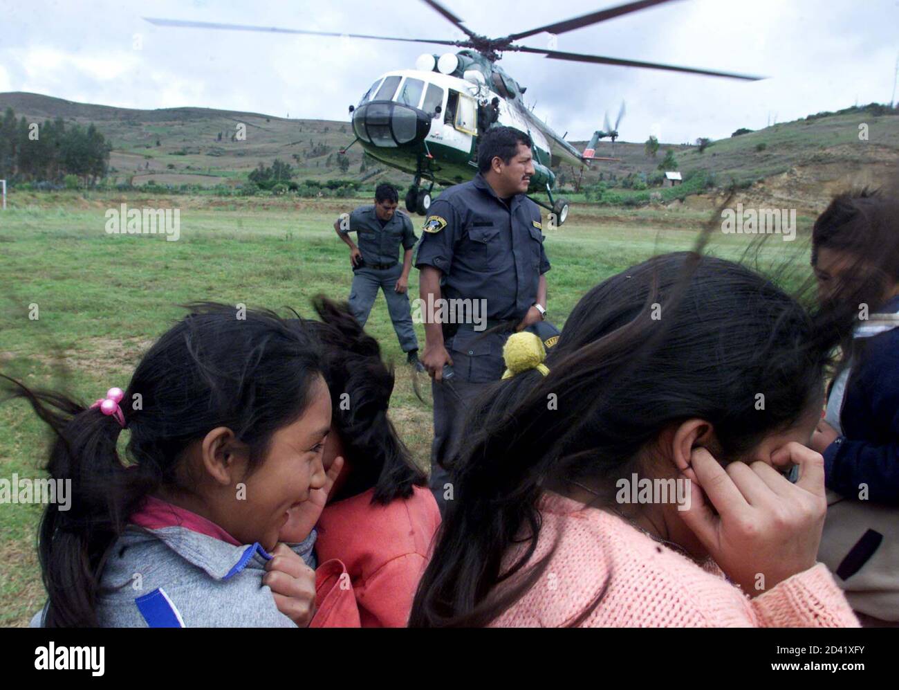 Andean girls hold their hands over their ears while a Peruvian police  helicopter departs January 10, 2003 to search for the Tans Peru Fokker-28  plane that was declared missing, in Lamud. A