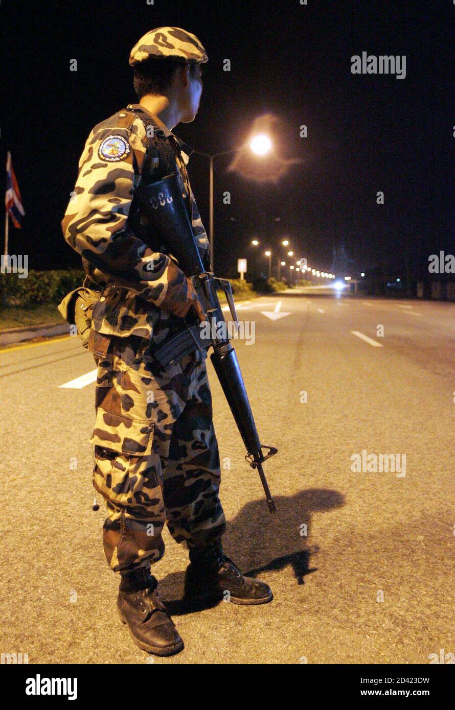 A soldier guards a checkpoint in Narathiwat province, 1,200 km (750 miles) south of Bangkok on November 1, 2004. Muslims worldwide have condemned the deaths of 78 men who suffocated last Monday after being crammed into army trucks and driven three hours to a military barracks. Seven more died from wounds suffered when security forces fired live rounds, teargas and water cannon to suppress a 1,500-strong crowd demanding the release of six detained villagers at a police station in Narathiwat province. REUTERS/Sukree Sukplang  SS/CP Stock Photo