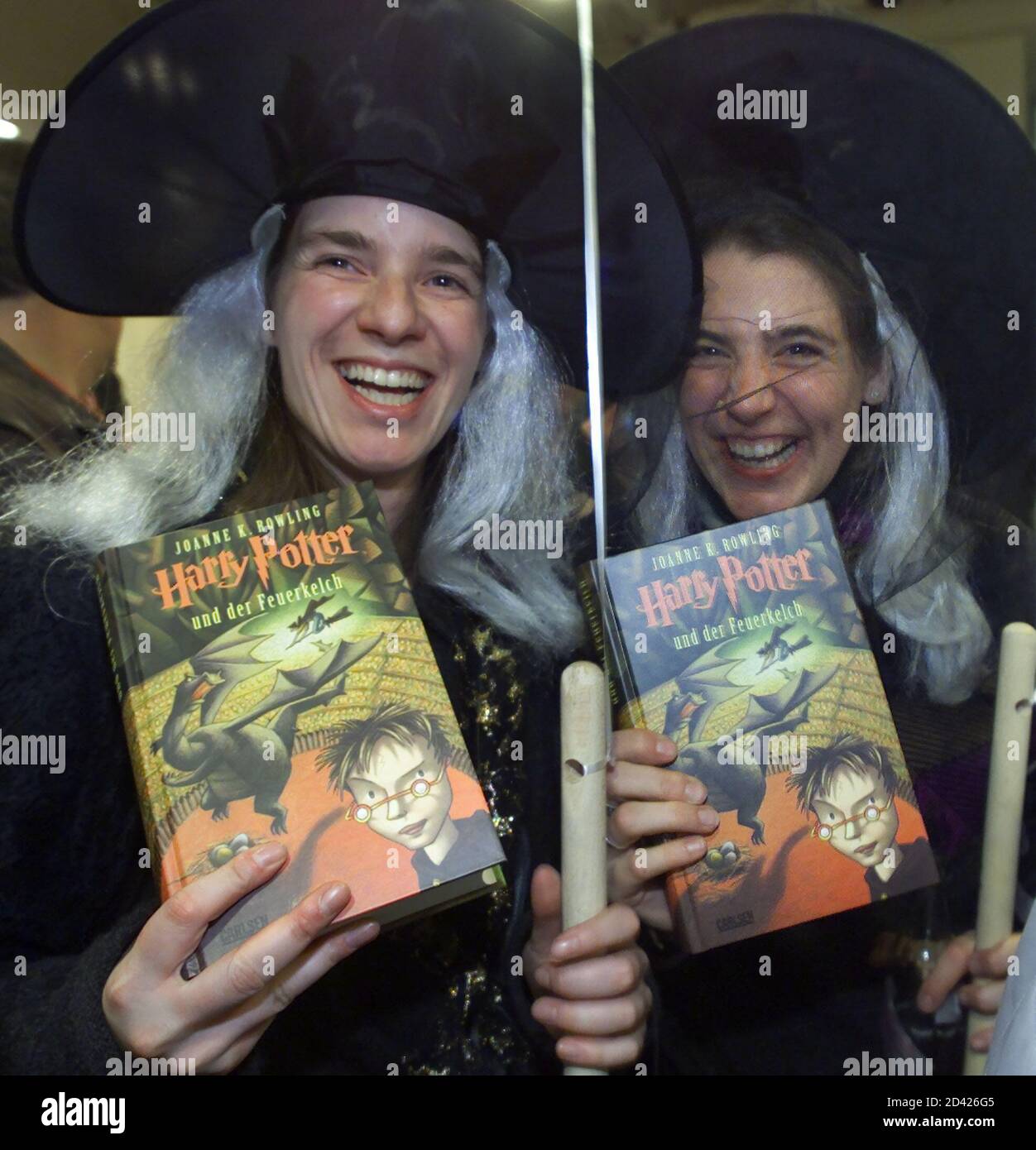 Two Harry Potter fans in wizards' clothings show the new fourth edition "Harry  Potter und der Feuerkelch" (Harry Potter and the Goblet of Fire) in a  bookstore in Cologne at midnight October