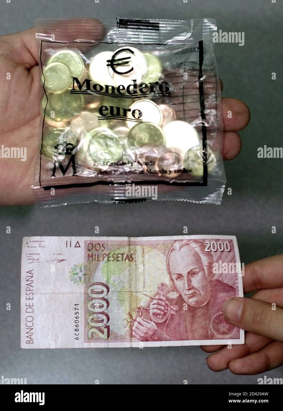 A Spanish Consumer Passes Over 2 000 Pesetas To Acquire A Bag Containing 12 02 Euro Coins At A Madrid Bank December 15 01 The Kits Are Available To The Public At Banks Across