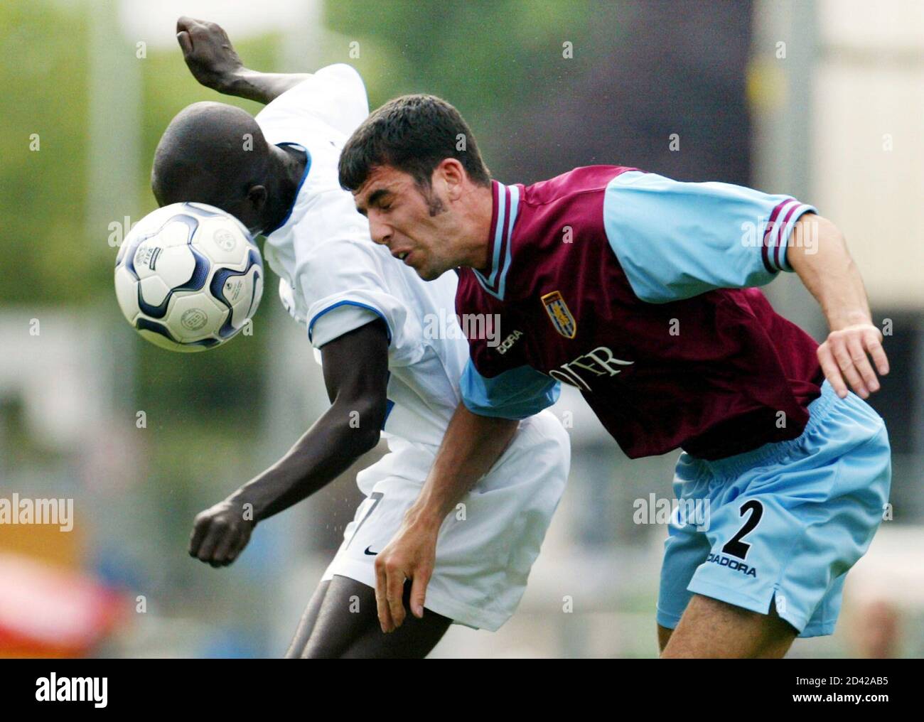 KANGA AKALE AND MARK DELANEY JUMP FOR A HEADER DURING THE UEFA INTERTOTO MATCH FC ZURICH VS. ASTON VILLA.    FC Zurich's Kanga Akale (L) and Aston Villa's Mark Delaney (R) jump for a header during their UEFA Intertoto third round, first leg soccer match in Zurich on July 21, 2002. REUTERS/Andreas Meier Stock Photo