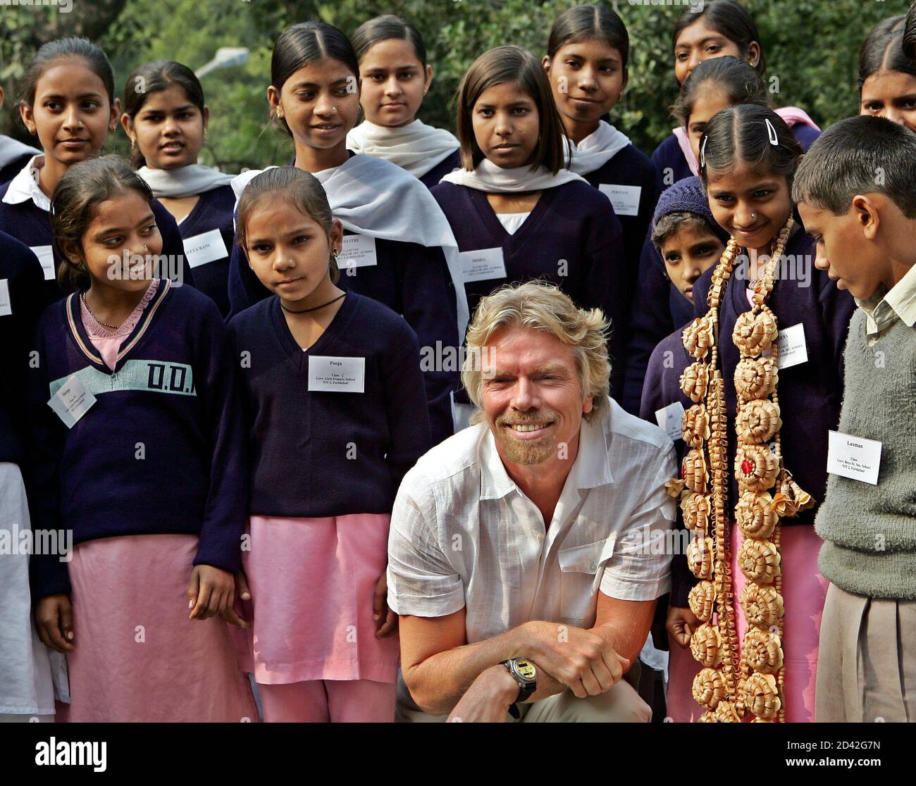 Chief Executive Officer of Virgin Atlantic Airlines Sir Richard Branson sits with Indian children in New Delhi.  Chief Executive Officer of Virgin Atlantic Airlines Sir Richard Branson sits with Indian children in New Delhi on November 27, 2004. The Shrimati Pushpa Wati Loomba Trust is commemorating the completion of five years of educating children of poor widows in India. REUTERS/Desmond Boylan Stock Photo