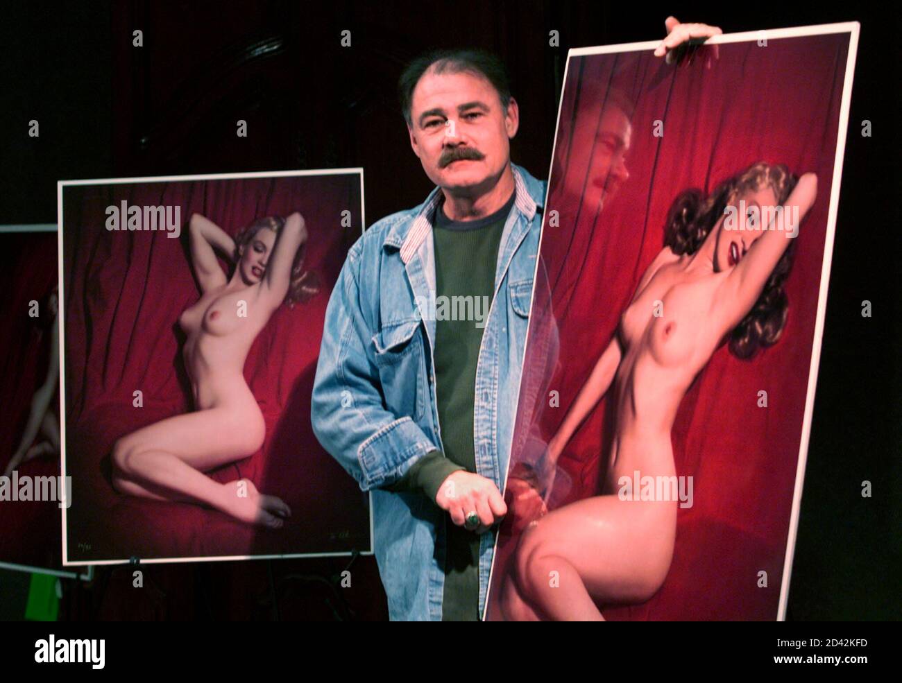Tom Kelley Jr., son of the late photographer Tom Kelley Sr., poses at Butterfields auction house in Los Angeles March 1, 2001 with the famous 'Red Velvet' series of photographs of Marilyn Monore taken by his father during a Hollywood photo shoot in 1949. The photograph at (R) will be sold only as one of four fine art prints, but the negatives from the photo (L) and other from the shoot as well as the intellectual property rights will be sold with an opening bid of $700,000 at auction March 22 in Los Angeles and via the Internet. The items were displayed during a media preview March 1, 2001 in  Stock Photo