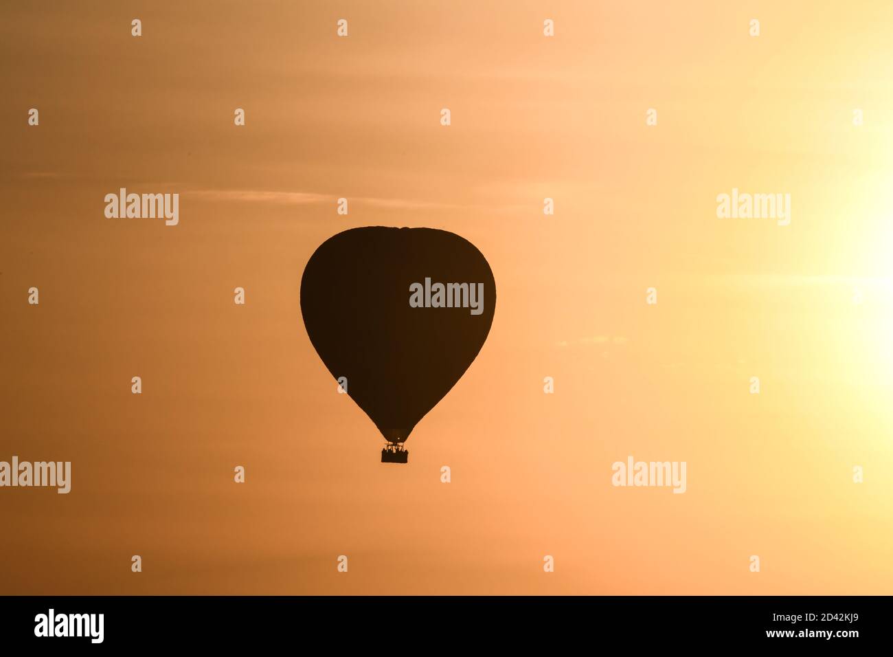 Silhouetted hot air balloon enjoying Serengeti Sunset in Kenya Stock Photo