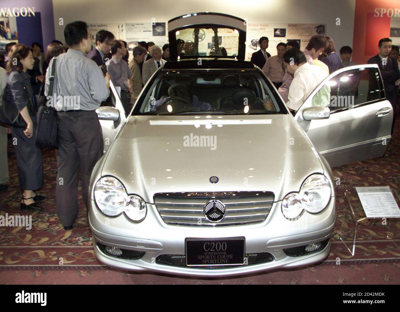 Japanese motor journalists crowd around the new Mercedes-Benz C-Class C200  Kompressor Sports Coupe Sportline in Tokyo June 26, 2001. DaimlerChrysler  Japan Co launched this new model in Japan on Tuesday, priced at